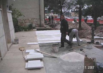 Počelo popločenje kamenom cementnih površina novog parka uz gradske zgrade