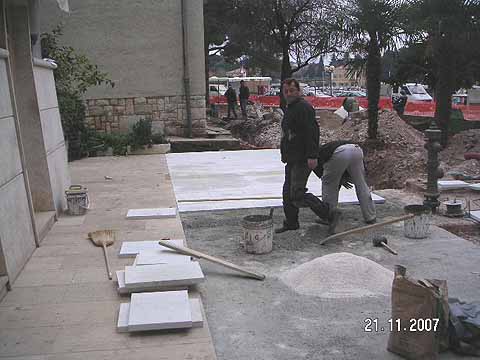 Počelo popločenje kamenom cementnih površina novog parka uz gradske zgrade
