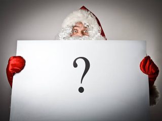 Santa Claus is holding white paper with question-mark.
