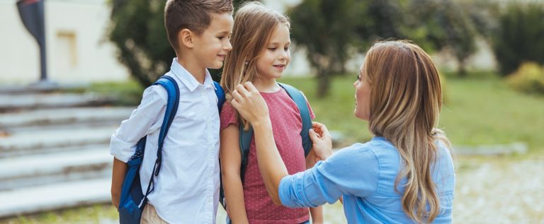 Mother,Saying,Goodbye,To,Her,Little,Children,Near,School.,Mother